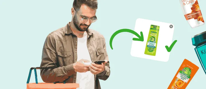 Man with a basket checks his phone, which shows a photo of the exact shampoo