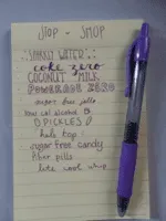 A neatly ruled notepad list written in purple pen, with the pen laid across it